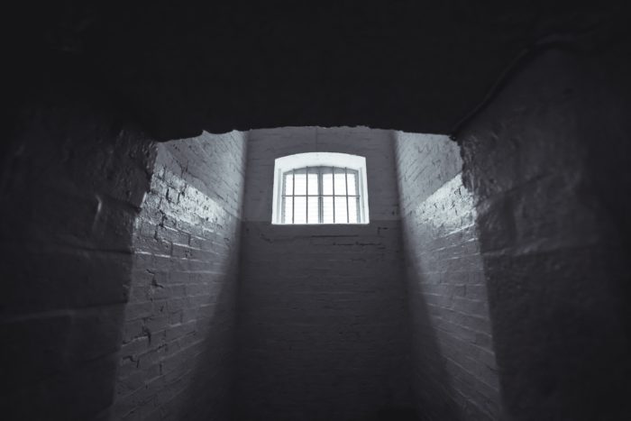Dark prison cell with light flooding through window