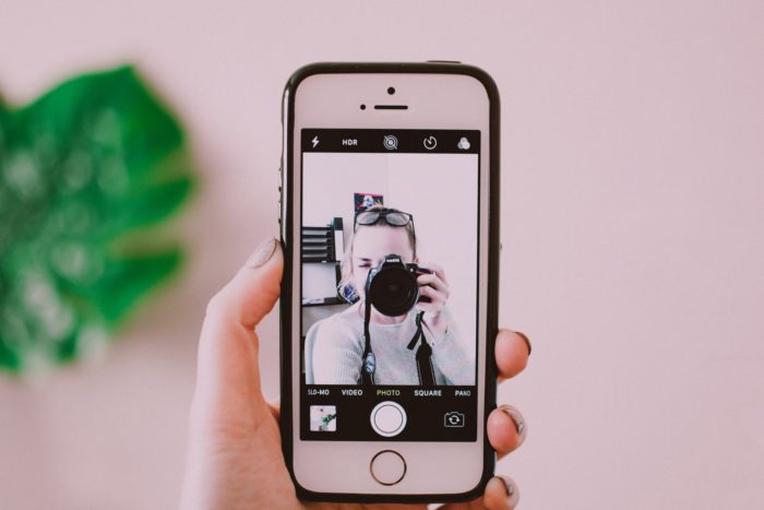 Girl taking photo of smartphone