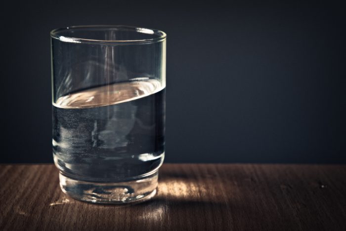 Glass of water standing on a table.